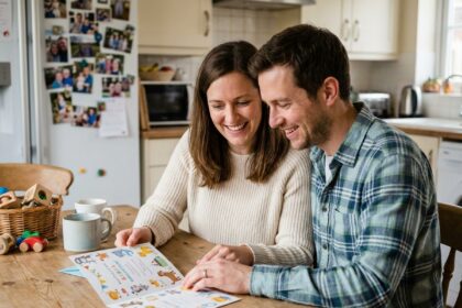 Jeune couple assemble une carte de naissance chaleureuse