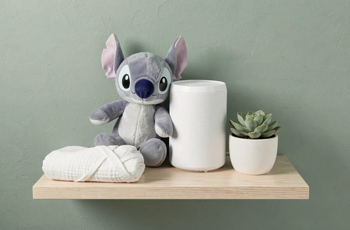 Peluche Stitch et veilleuse musicale sur une étagère de chambre bébé minimaliste